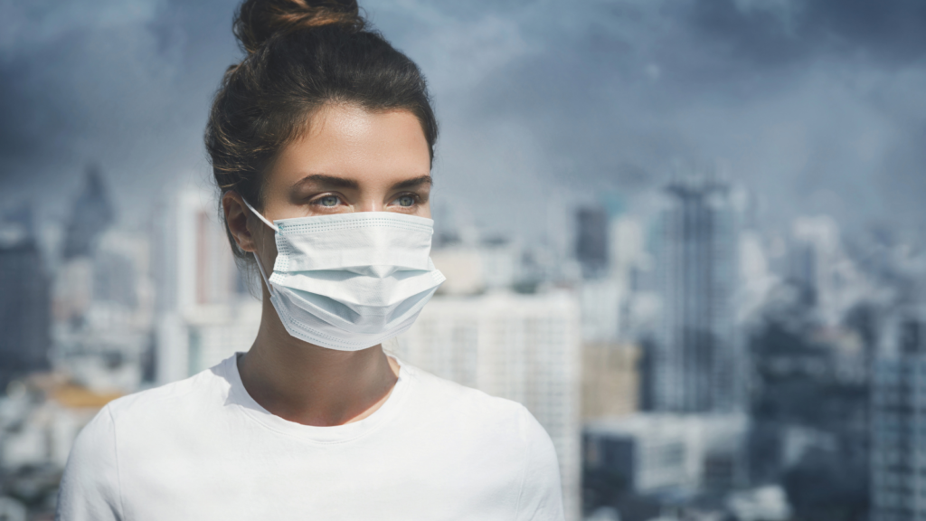 Woman wearing mask, polluted city backdrop